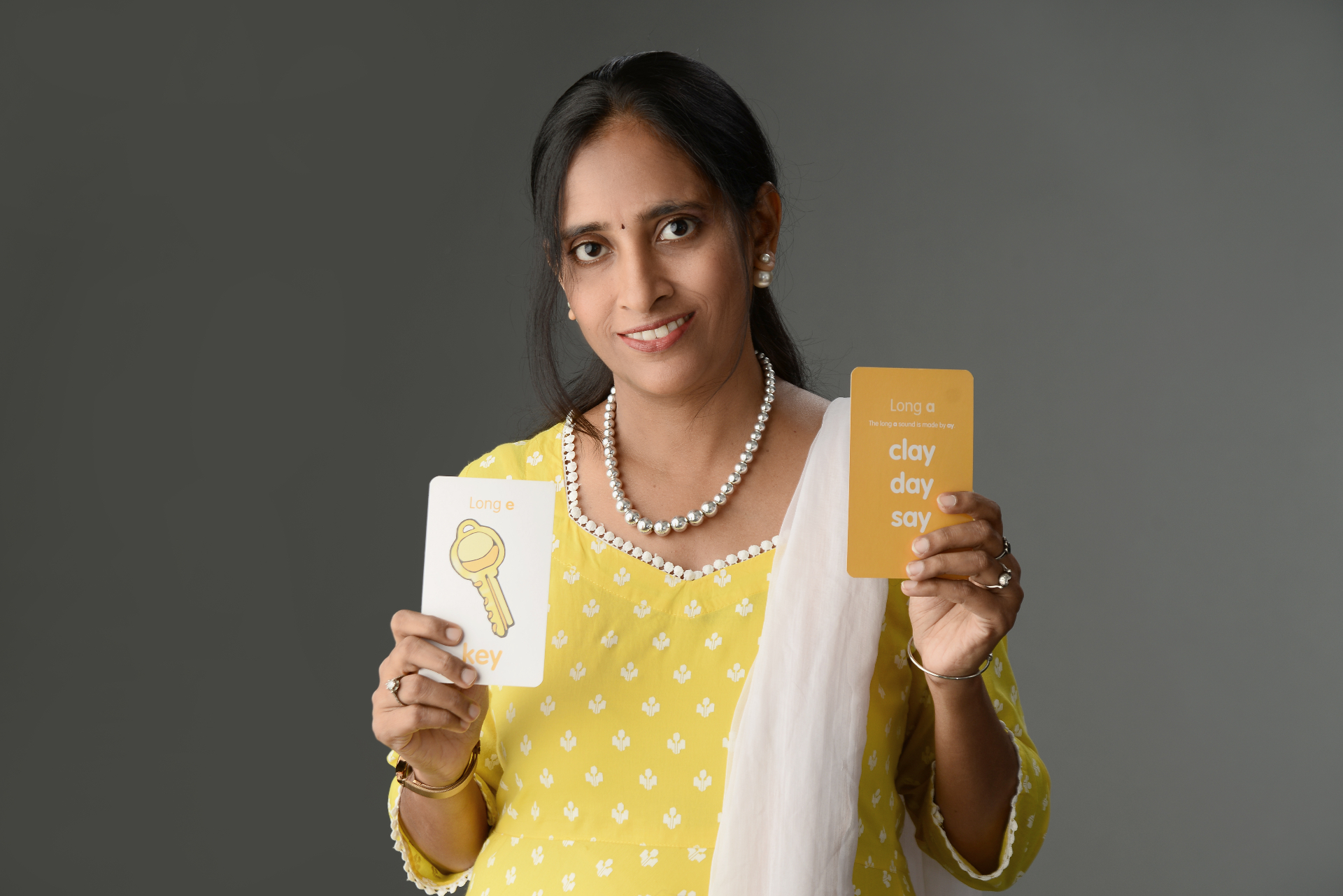 Gomathy Narayanan holding phonics flashcards